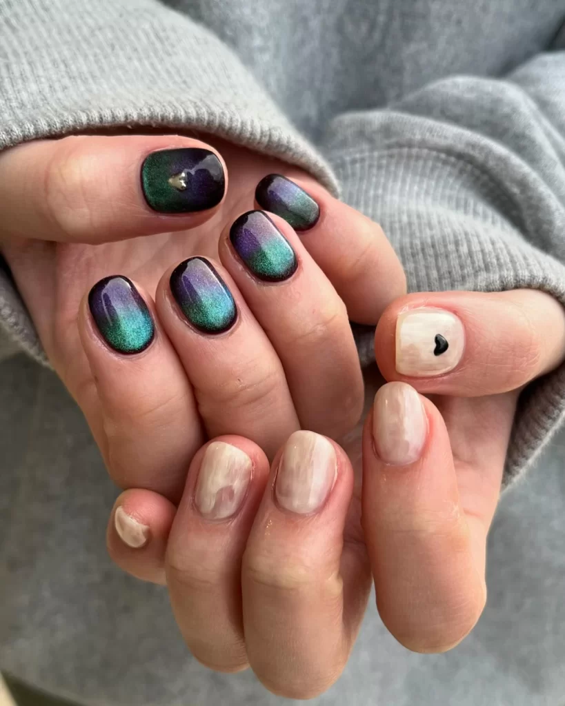 Korean gel nails in aurora cat eye effect showing green and purple shimmer with white accent nail