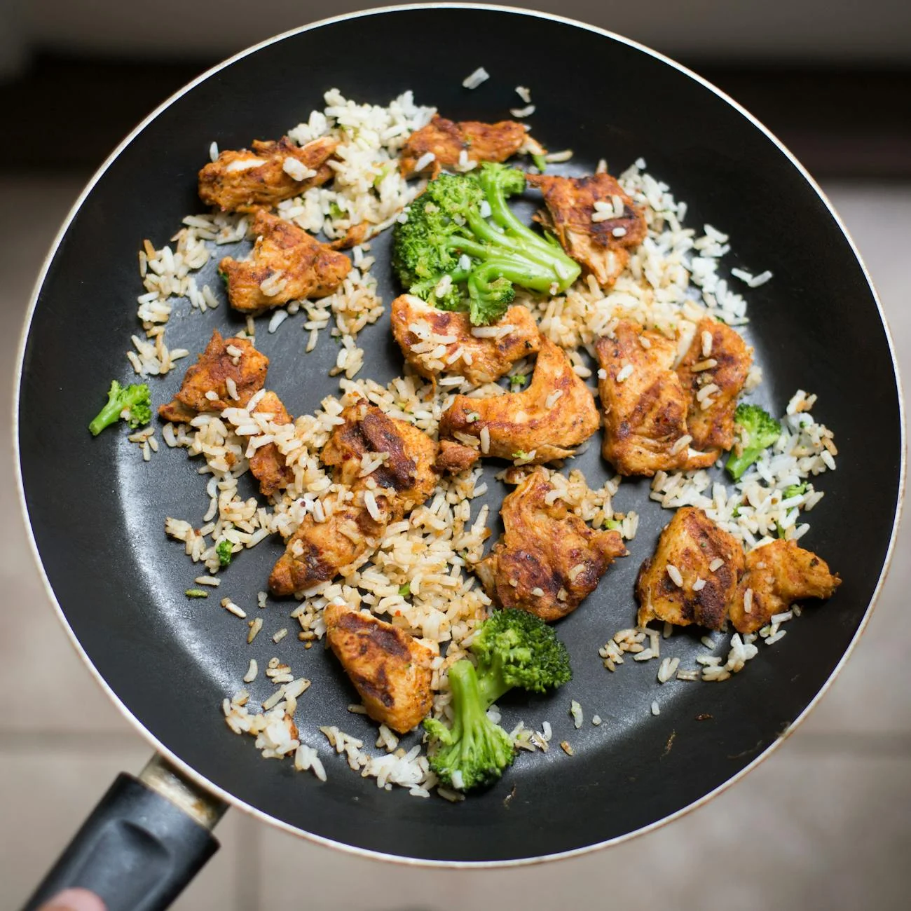 white rice chicken and broccoli on black non stick pan