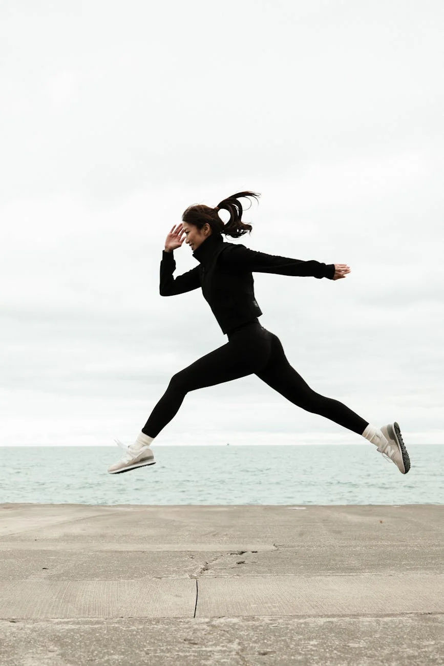dynamic woman leaping by ocean in winter
