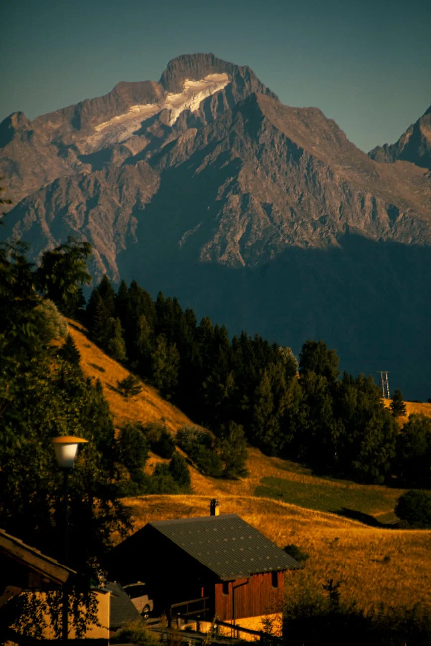scenic mountain view with rustic cabin at sunset