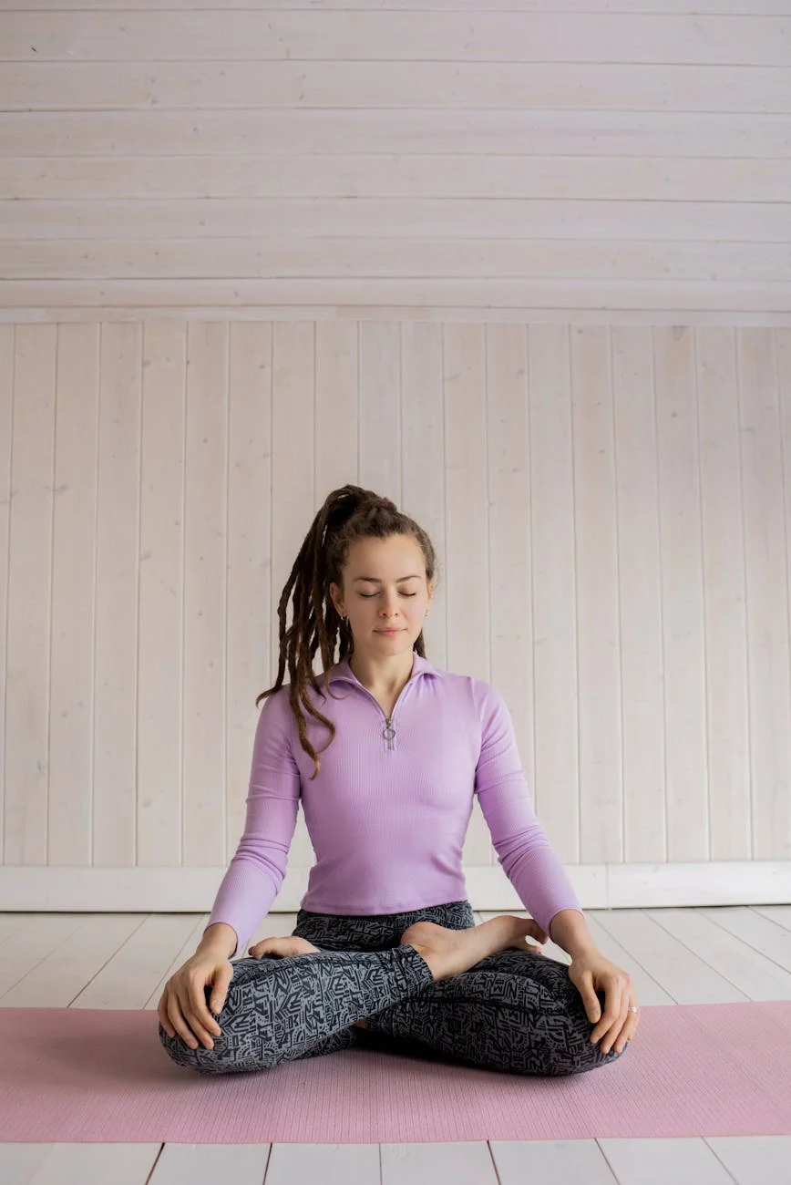 woman in purple long sleeve shirt and black denim leggings sitting on mat