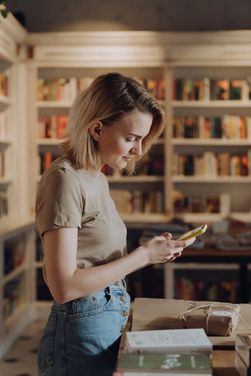 woman in white t shirt and blue denim shorts holding smartphone