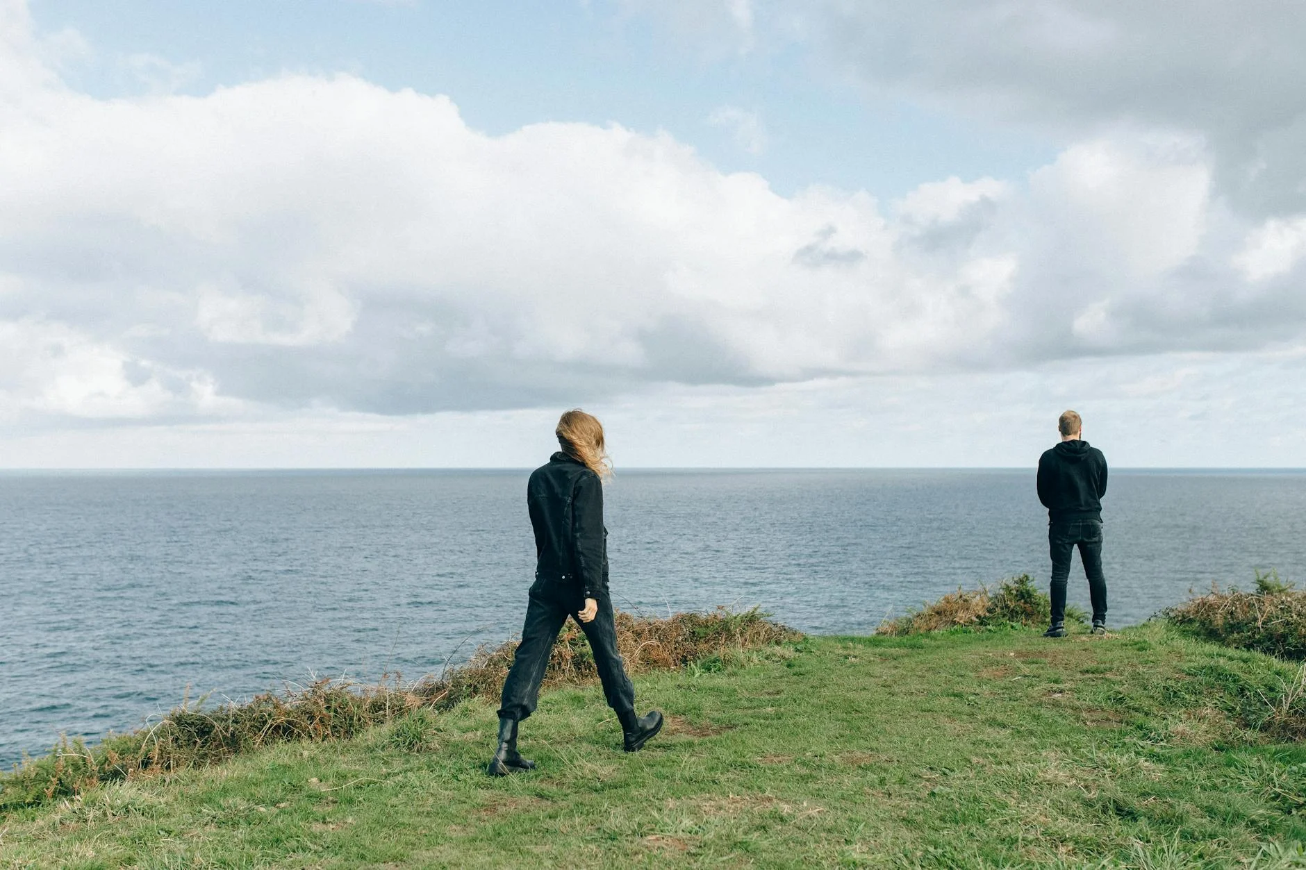 two people standing on a cliff