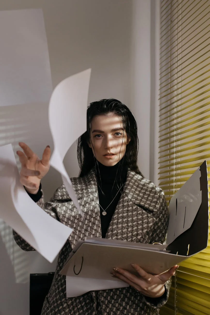 a woman in gray and white coat throwing papers from the folder