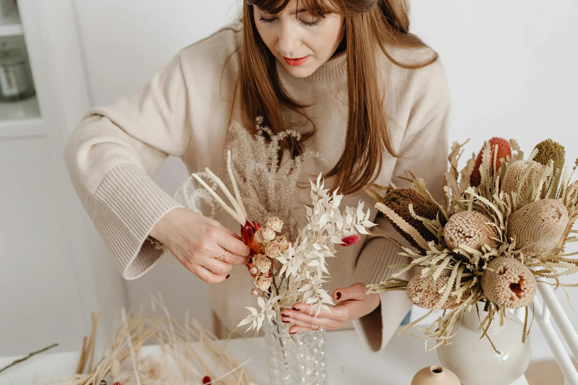 a florist arranging dried flowers in a vase