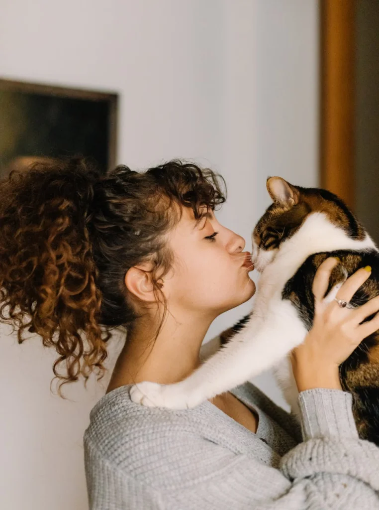 a woman kissing her cat
