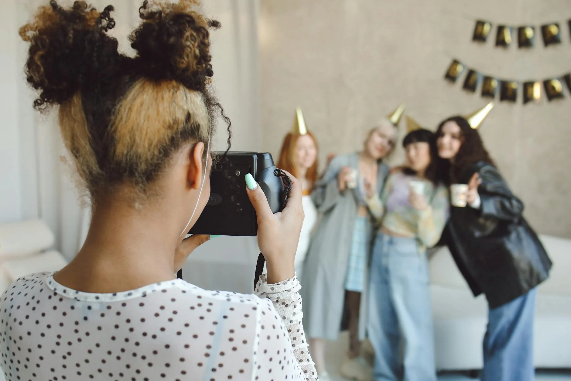 girl photographing friends at birthday party