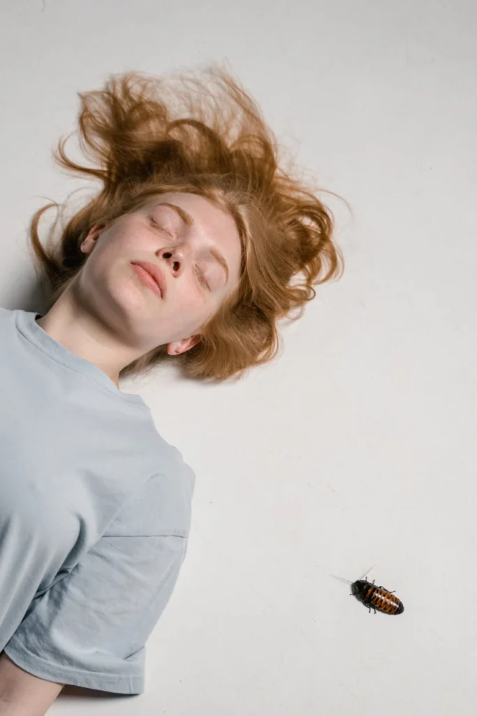 close up photo of a fearful woman lying down while overcoming her fear of cockroaches