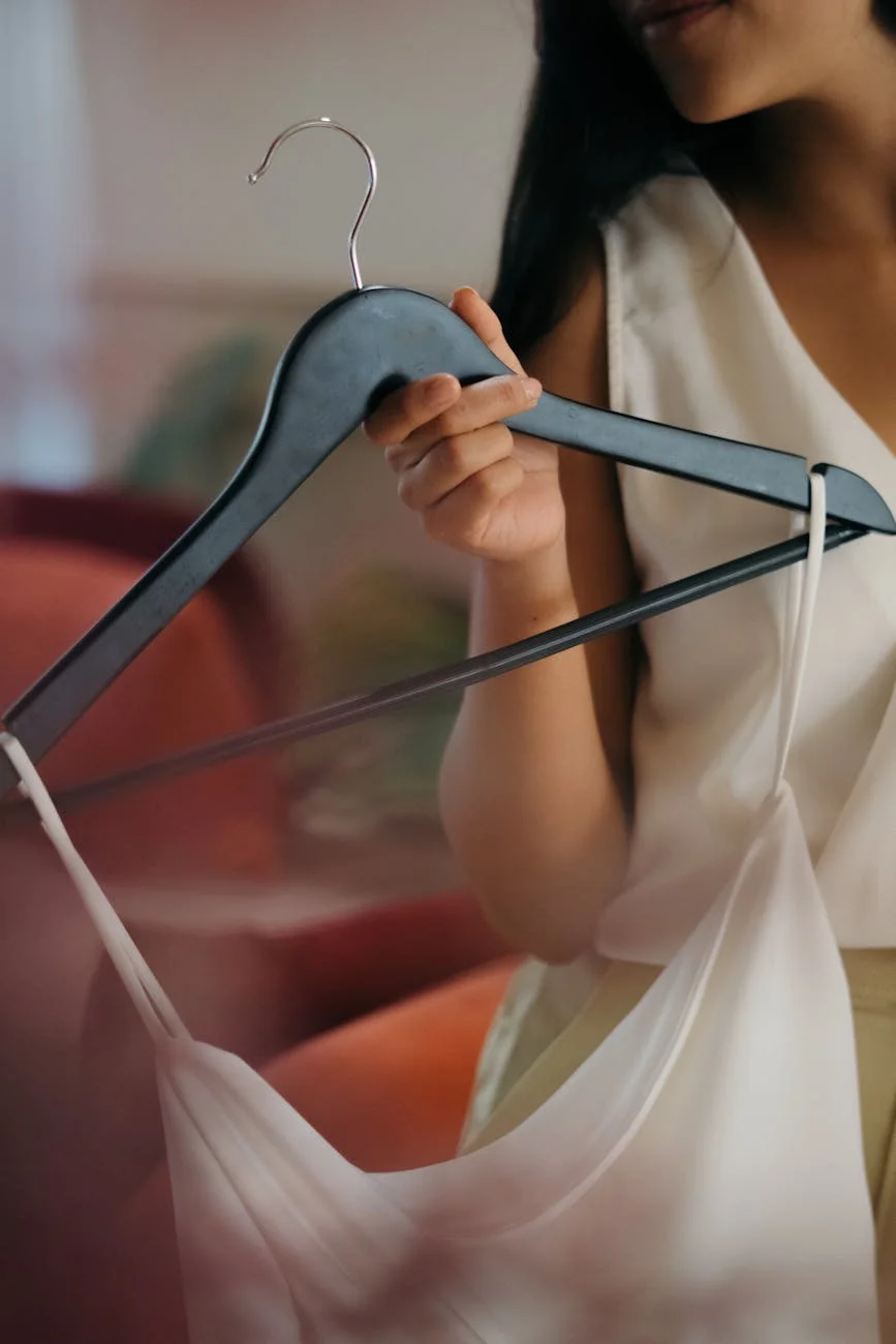 a woman in white top holding black hanger