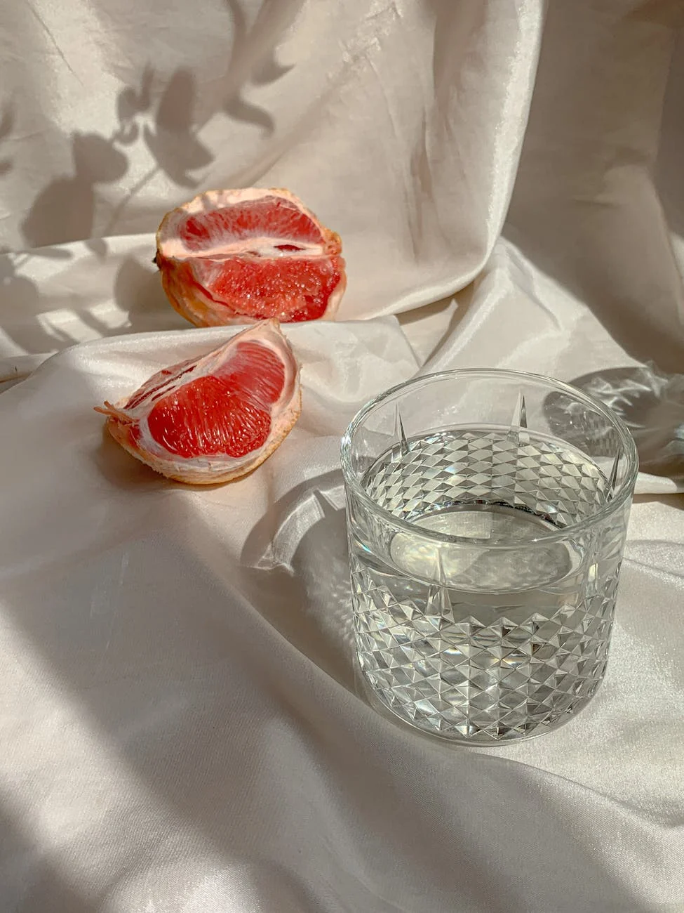 clear glass with water on white textile