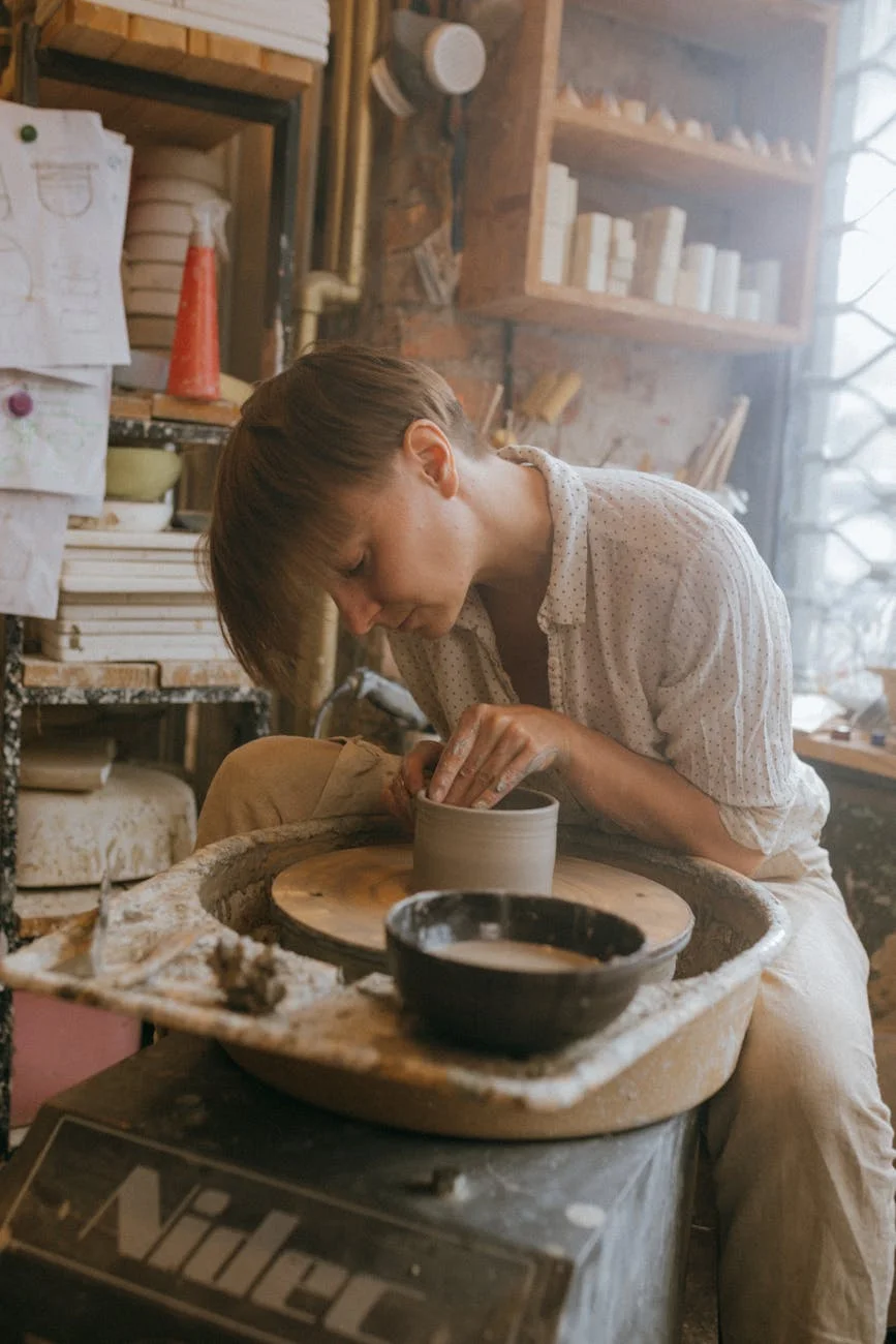 woman in gray sweater holding gray ceramic mug