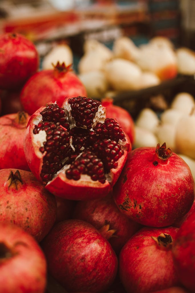 Vibrant close-up of a fresh organic pomegranate with seeds exposed, showcasing ripe fruit abundance.