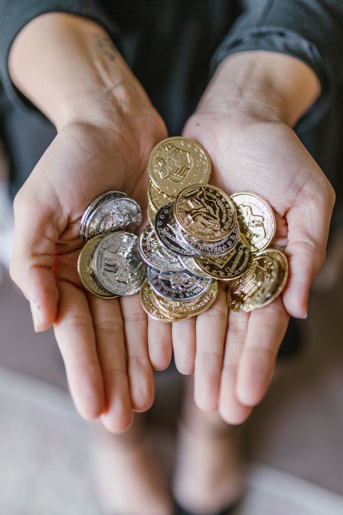 A close-up of hands holding various coins symbolizing wealth and finance.