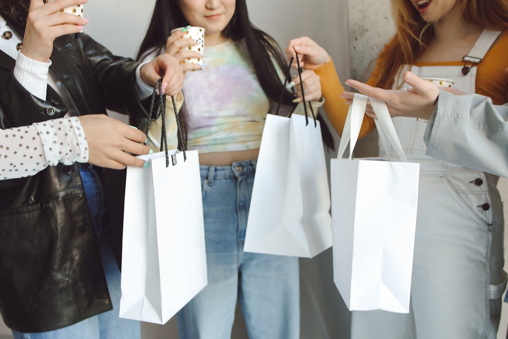 A group of diverse friends celebrating with drinks and exchanging gift bags indoors.