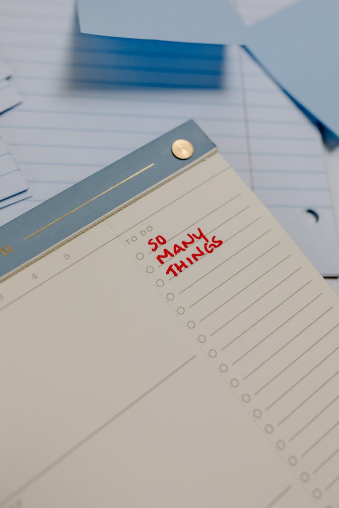 A planner with 'So Many Things' written, surrounded by loose notes.