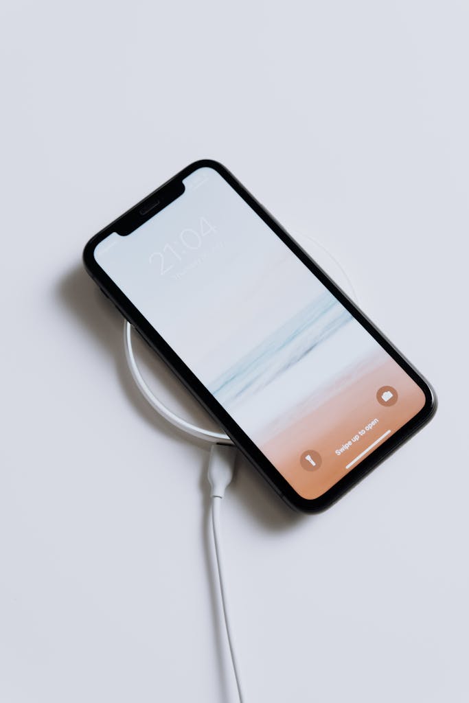 A sleek smartphone charging wirelessly, showcasing minimalist design and modern technology.