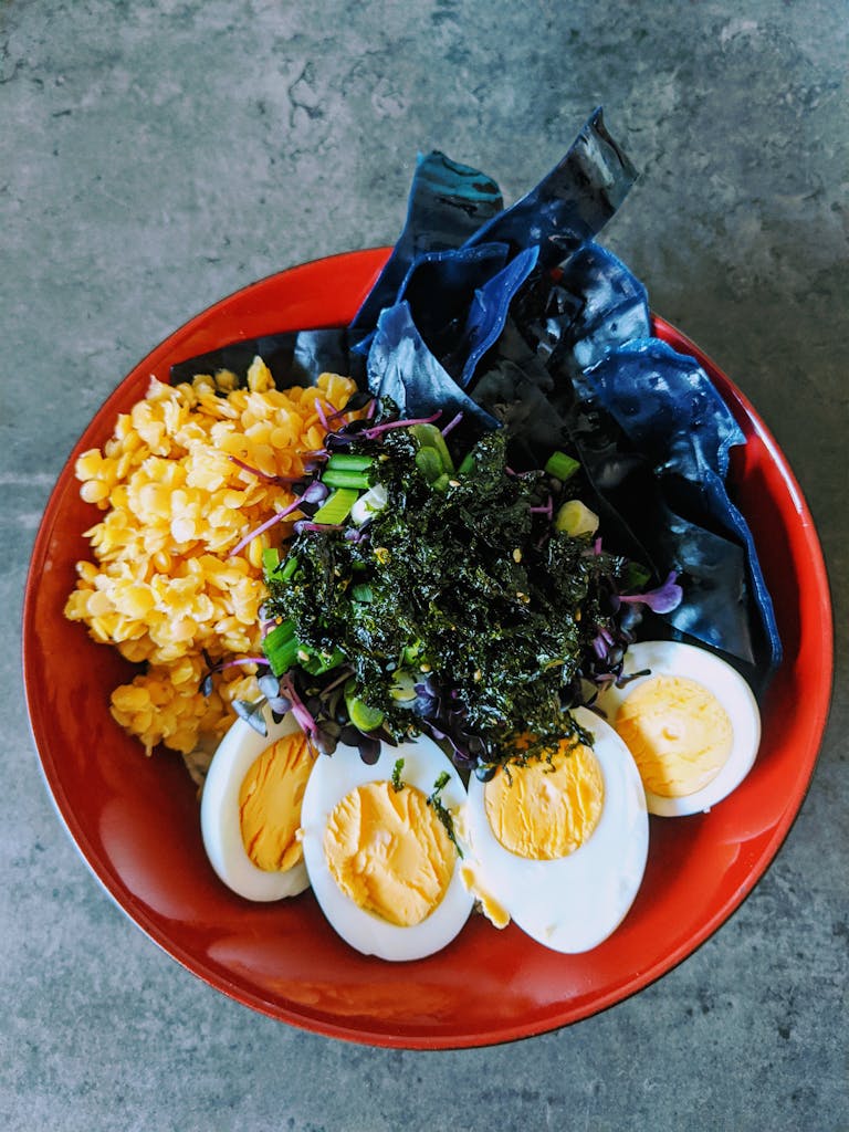 A vibrant and nutritious bowl featuring eggs, seaweed, and fresh vegetables.