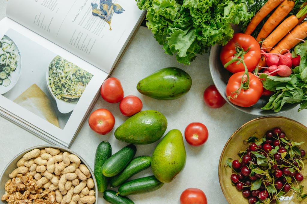 An appetizing display of fresh fruits and vegetables with a cookbook, perfect for healthy recipes.