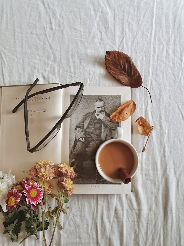 Autumn-themed still life featuring a coffee cup, book, and dried leaves.
