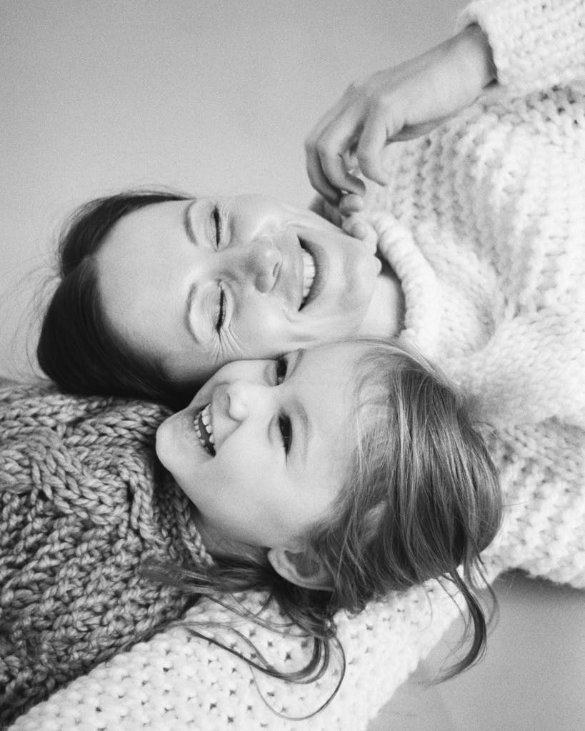 Black and white photo of a loving mother and daughter laughing together.