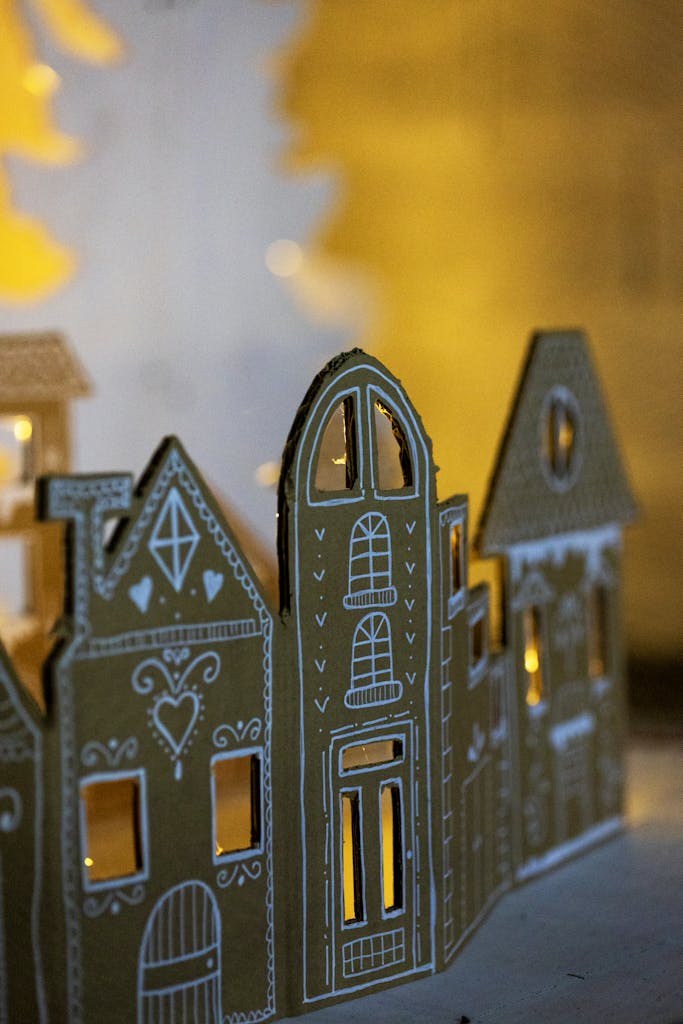 Cozy cardboard houses with intricate designs illuminated by warm ambient lighting, perfect for festive decor.