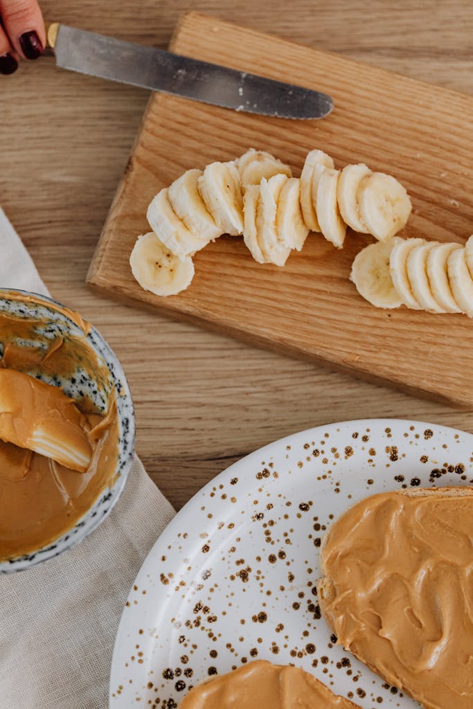 Delicious slices of banana paired with creamy peanut butter on a wooden board.