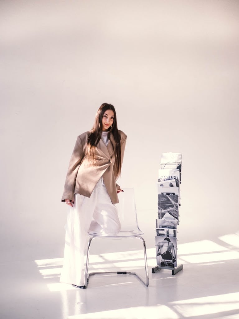 Fashionable woman in a minimalist office with natural light and artistic decor.