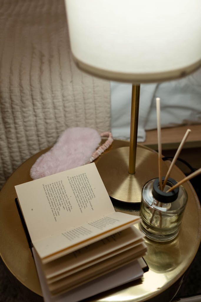 Inviting bedroom scene featuring a bedside table with a lamp, open book, and diffuser for a relaxing atmosphere.
