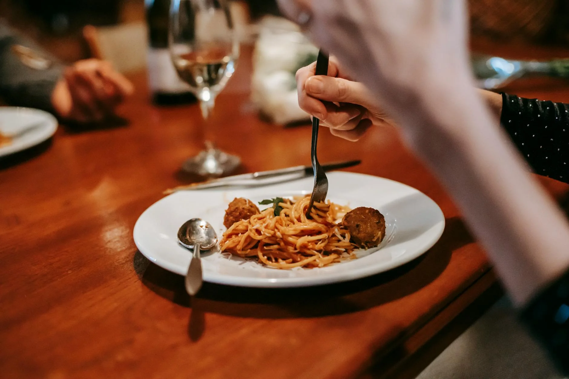 crop unrecognizable woman eating delicious pasta with meat balls