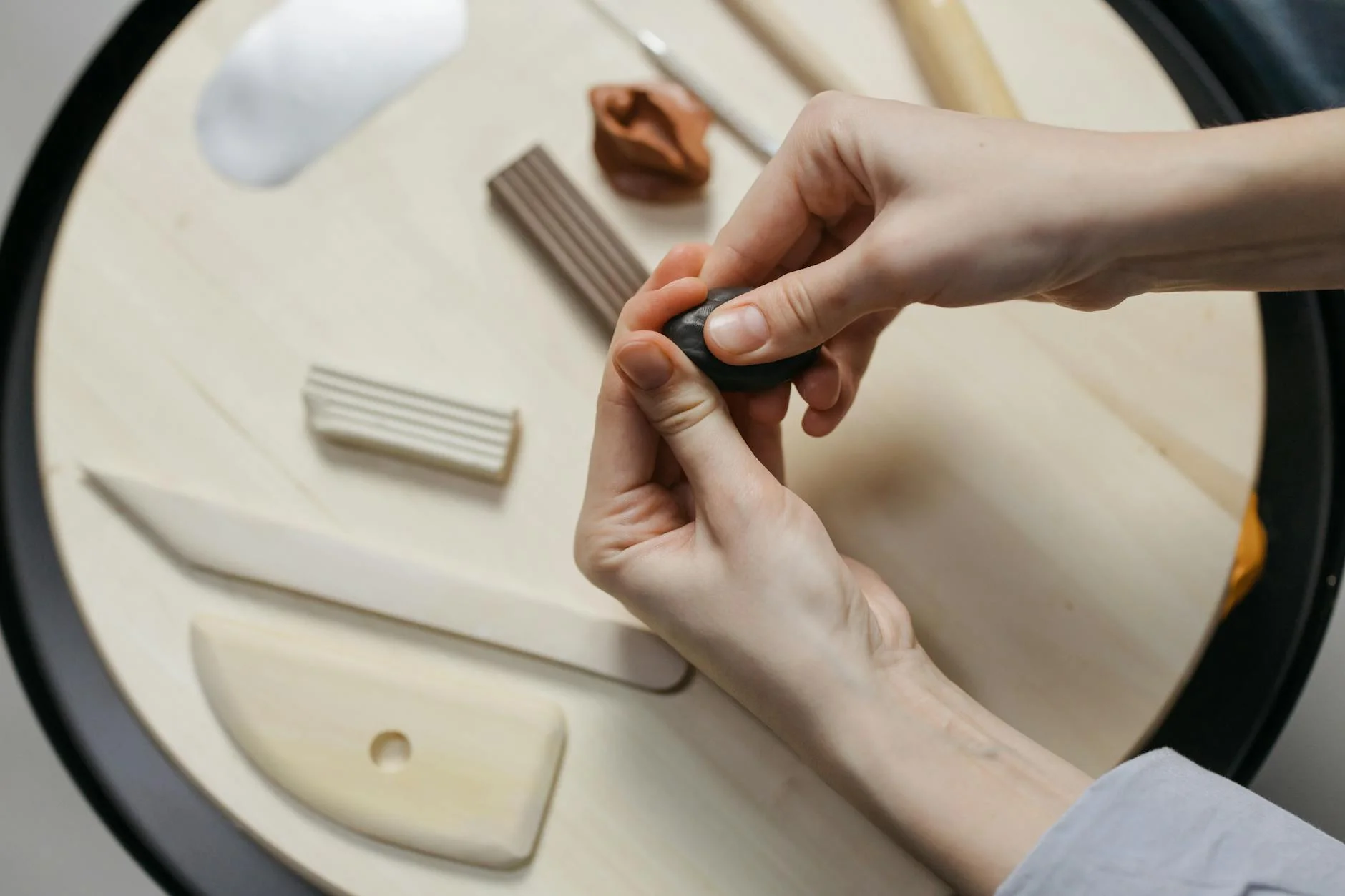 a person holding a black clay