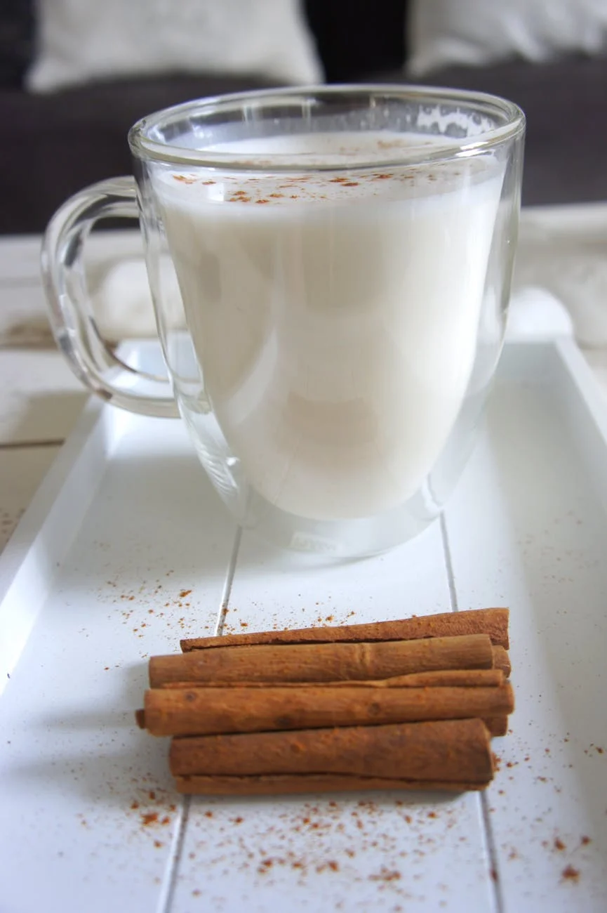 cinnamon sticks beside the glass of milk