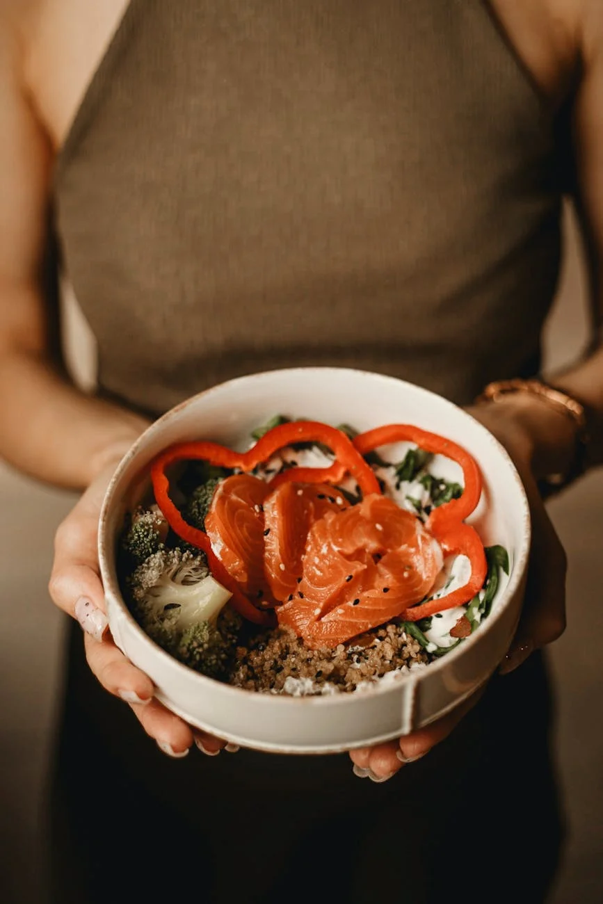 a person holding bowl salmon rice toppings