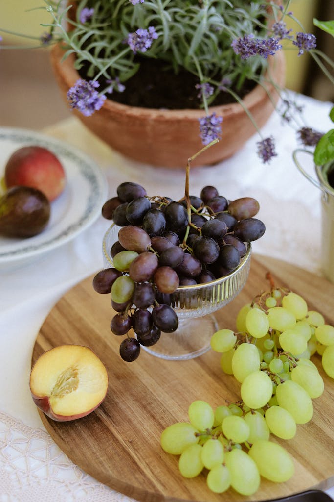 Tablescape with grapes, peach, and lavender plants in natural light setting.