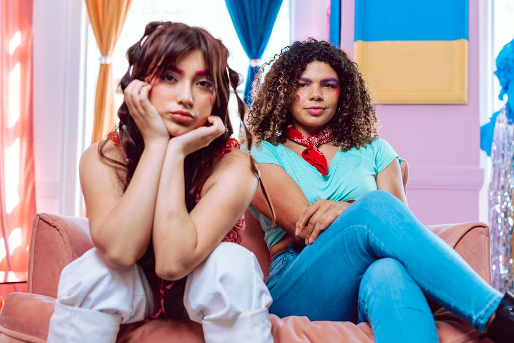 Two fashionable Gen Z friends relaxing indoors, embracing vibrant style and colorful aesthetics.