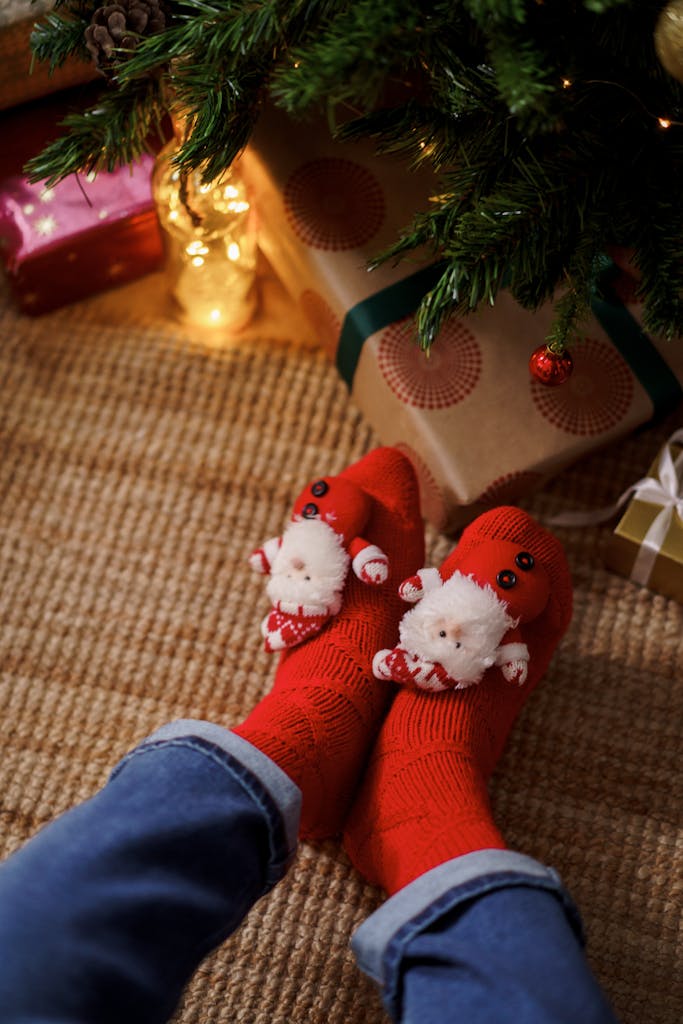Warm holiday scene with red Santa socks under Christmas tree. Perfect festive vibe.