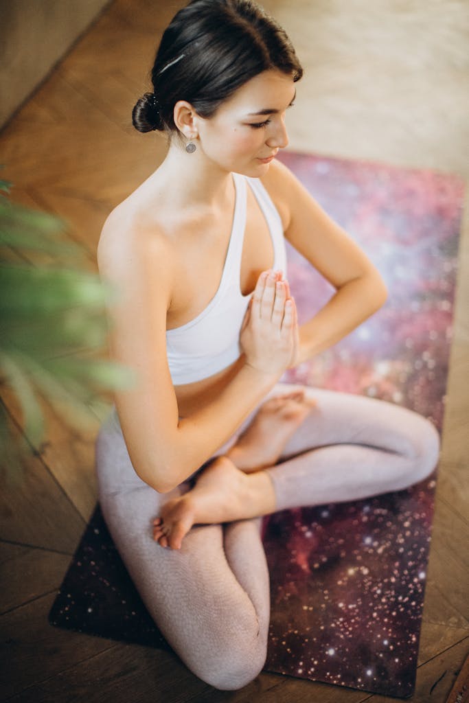 Woman in yoga pose indoors promoting mindfulness and relaxation.