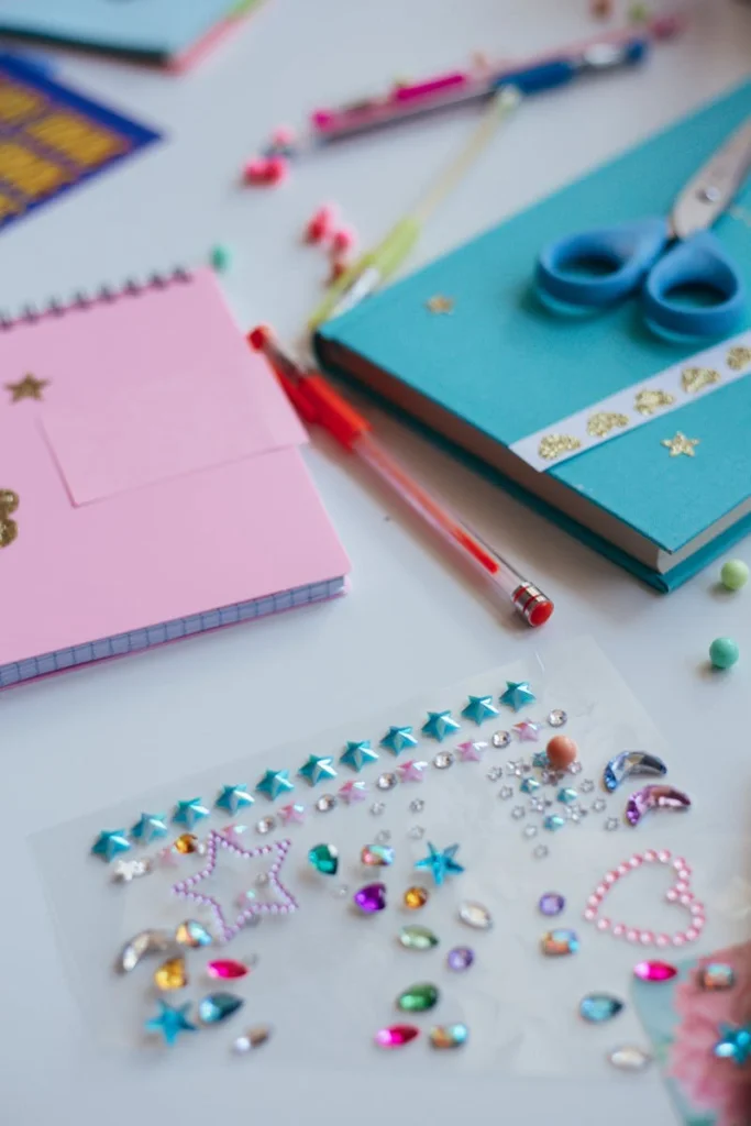 Vibrant flat lay of colorful stationery including notebooks, pens, and decorative stickers.