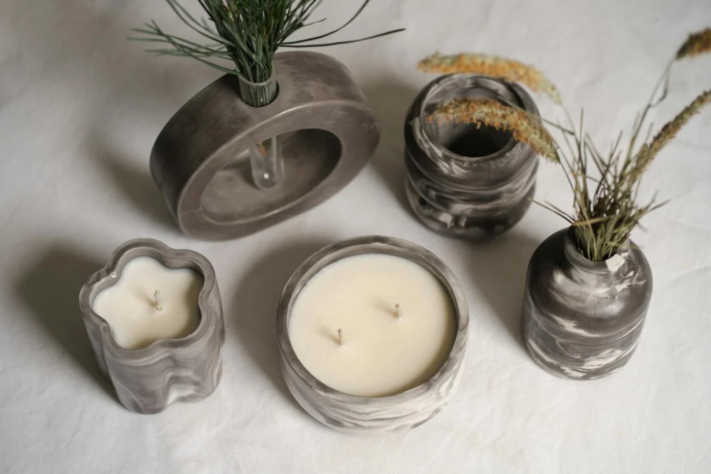 Artistic arrangement of minimalist ceramic vases and candles on a neutral backdrop