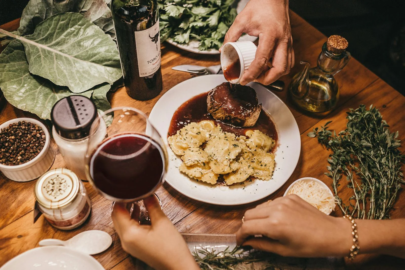 A delicious meal with wine, herbs, and richly seasoned meat prepared indoors.