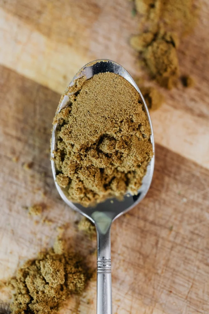 A detailed close-up of ground cumin on a spoon, showcasing its texture.