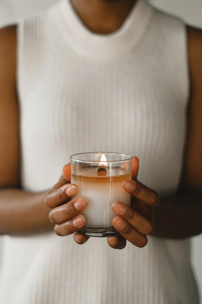 A calming image of a woman holding a lit candle, perfect for promoting relaxation and tranquility.