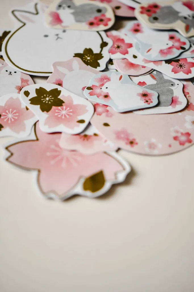A collection of adorable rabbit and sakura flower stickers arranged on a soft beige surface, perfect for spring decoration.