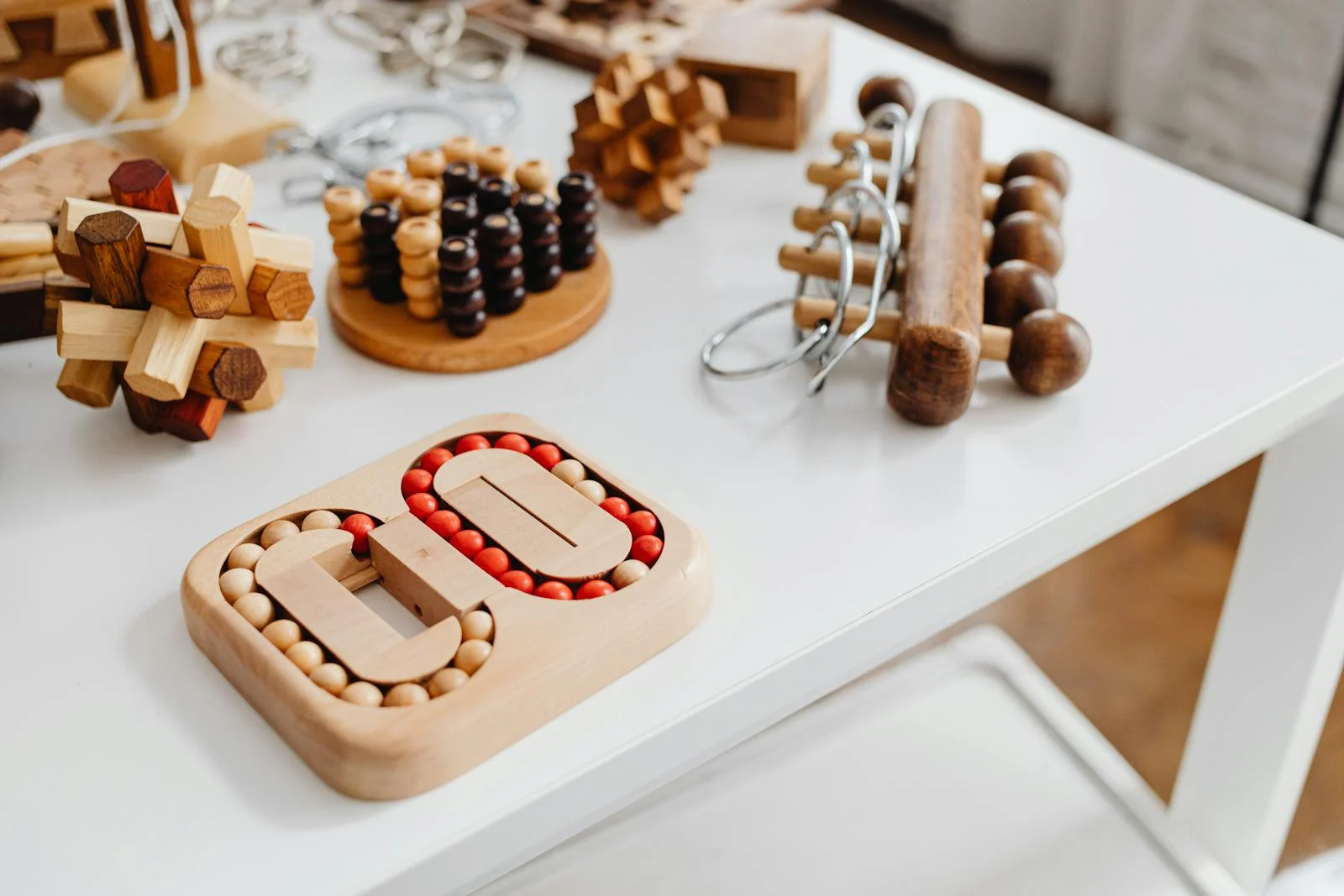A collection of wooden brain teasers and puzzles on a table, showcasing various designs and structures.