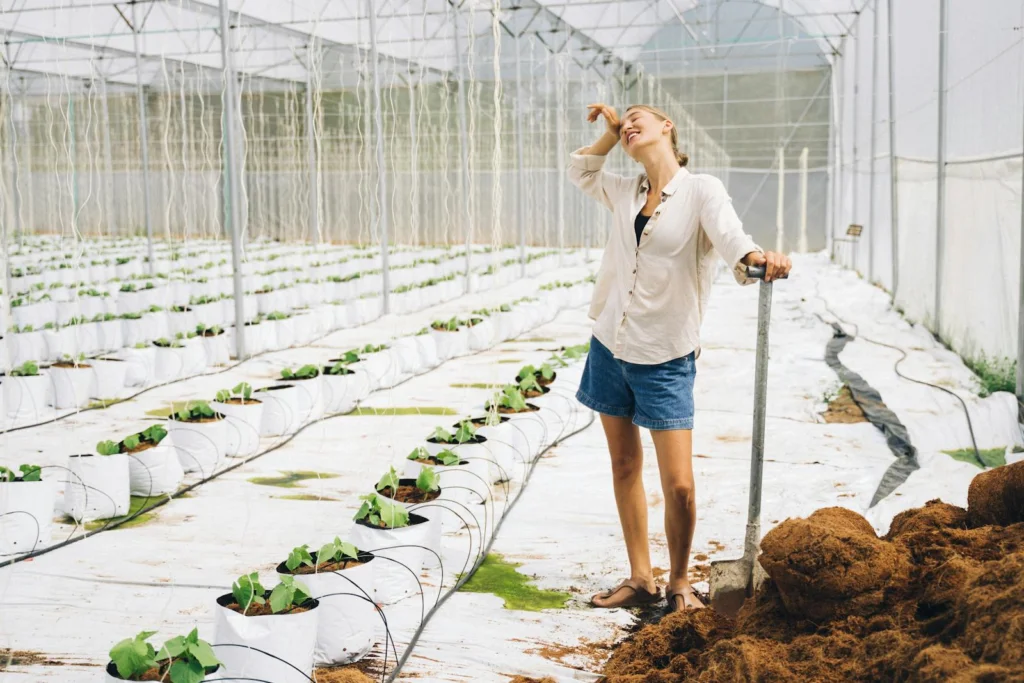 A woman enjoying her work in a greenhouse, showcasing modern farming techniques and sustainable agriculture.
