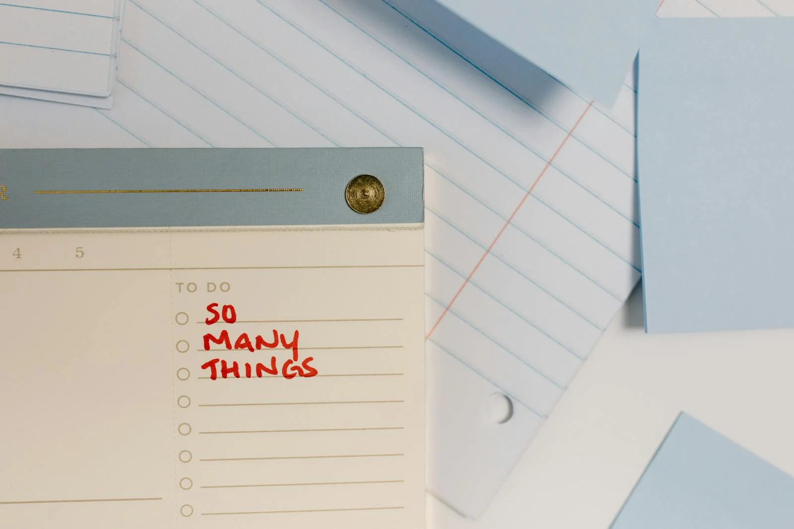 Close-up of a notepad with 'So Many Things' written, surrounded by lined paper