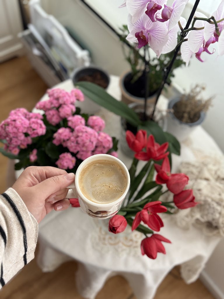 A cozy indoor scene with vibrant flowers and a steaming coffee for relaxation.
