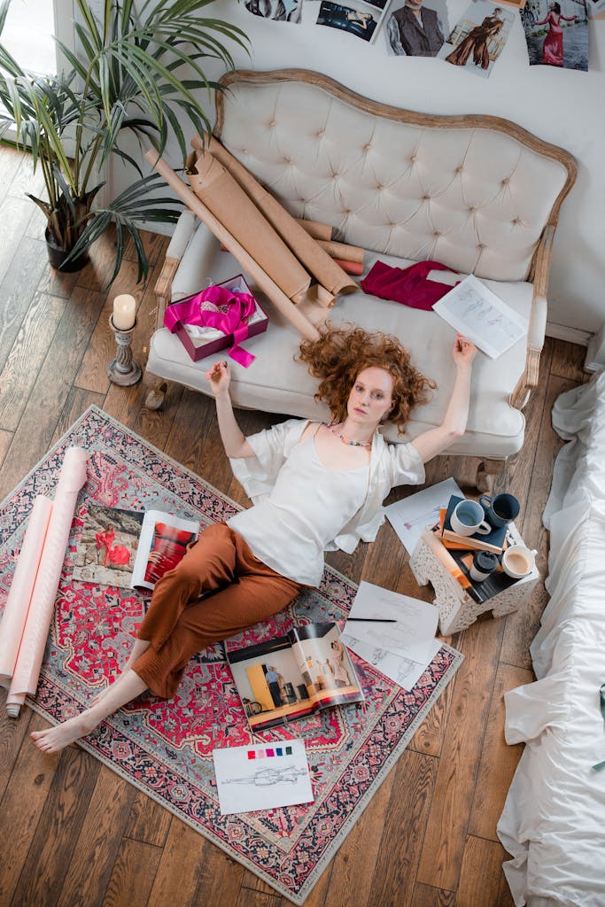 A fashion designer relaxing at home surrounded by design materials, showcasing creativity and inspiration.