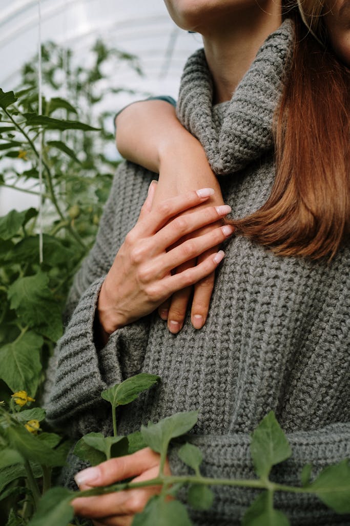 A tender embrace amidst green plants in a greenhouse, conveys warmth and connection.