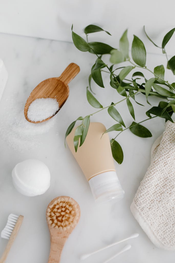 Aesthetic arrangement of natural bath essentials with leaves on a marble surface.