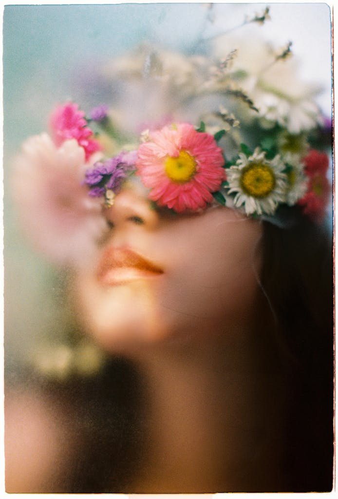 Artistic portrait featuring a woman with a flower crown, blurred, and ethereal.